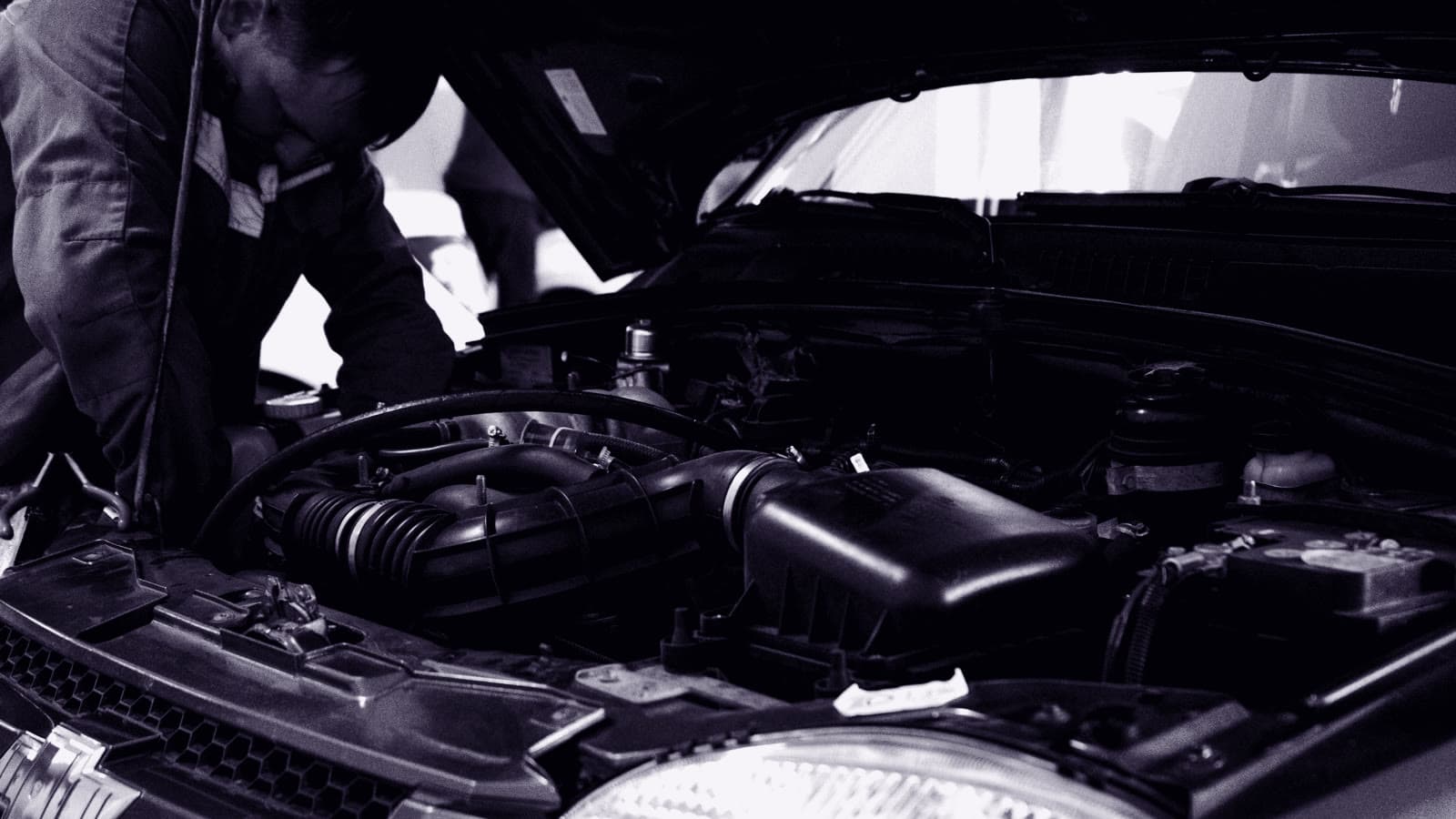 A technician working under the hood in the service drive
